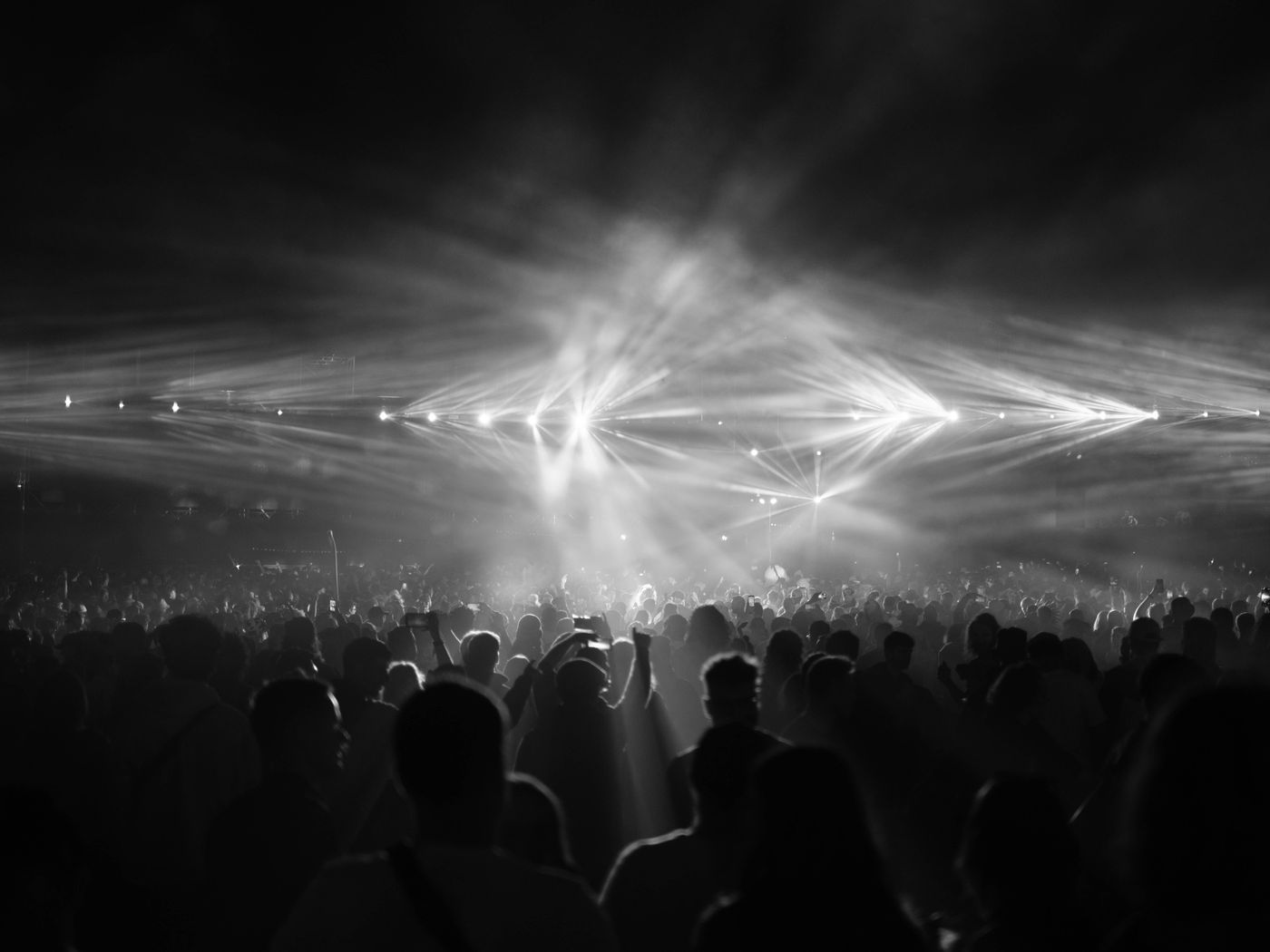 A packed crowd at a night event under stage lighting