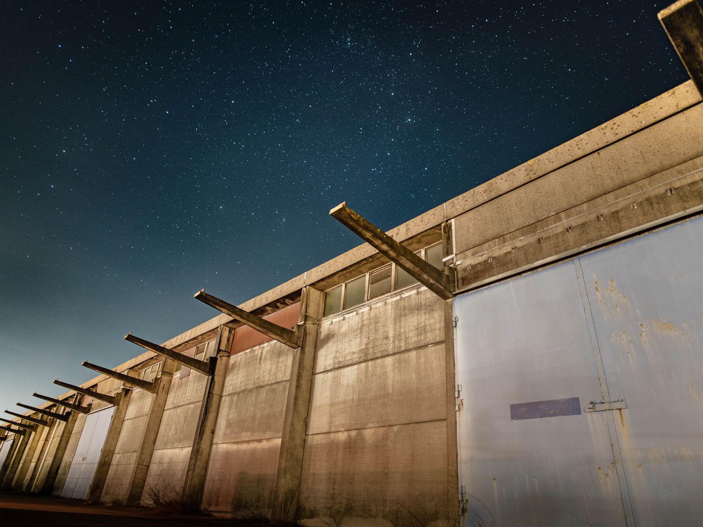 A commercial warehouse and yard under floodlight at night